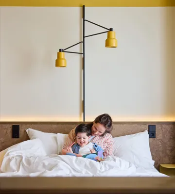 Mother and young son snuggling in bed in The Studio