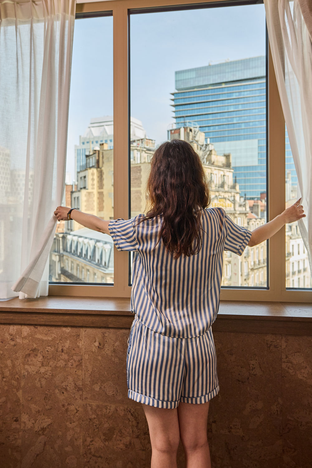 Girl opening window in Brussels